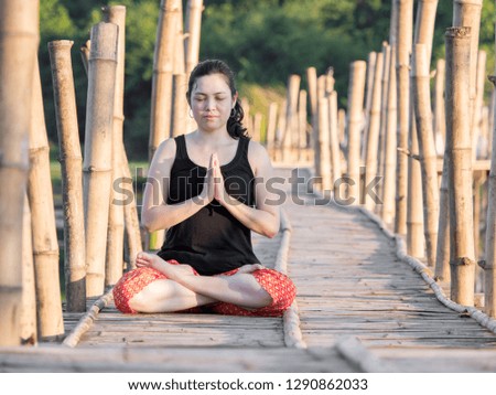 Asian woman Practicing yoga on the Bamboo bridge