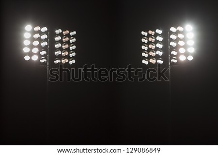 Stadium lights against dark night sky backgroundon Royalty-Free Stock Photo #129086849