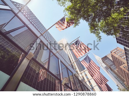 Looking up at American Flags in downtown New York, color toned picture, USA.