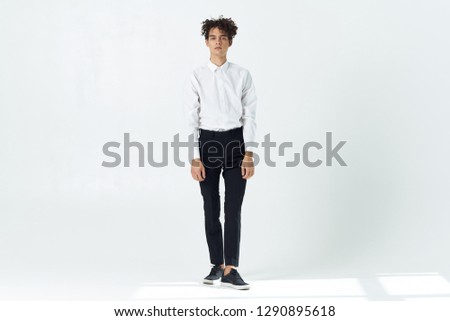 Business man in a white shirt in dark trousers stands in full growth