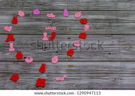 Big heart made of colorful little toys. On wooden background, photo bokeh. Holiday, Valentine's Day. Postcard with copy space.
