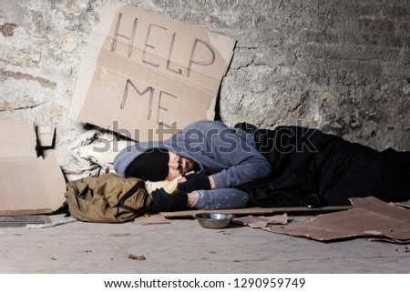 Beggar man in old clothes sleeping on the street