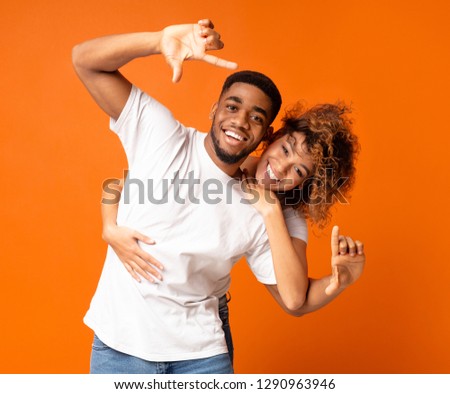 True love and memories for future. Just married black couple hugging, making frame with hands, taking picture with imaginary camera
