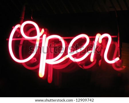 A neon "open" sign glowing red in the window of a restaurant.