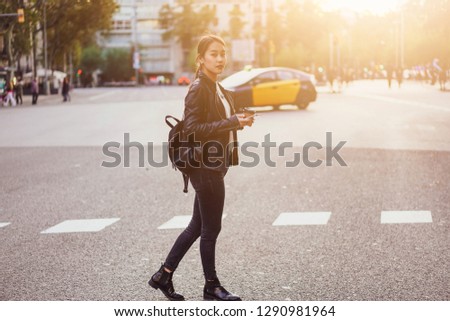 Young successful designer going to the office reading good news from friends on mobile phone and enjoying morning take away coffee - Image
