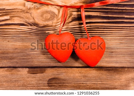 Two red hearts on rustic wooden background. Top view