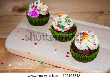 Muffins on a wood cutting board. cream decoration. place for text.