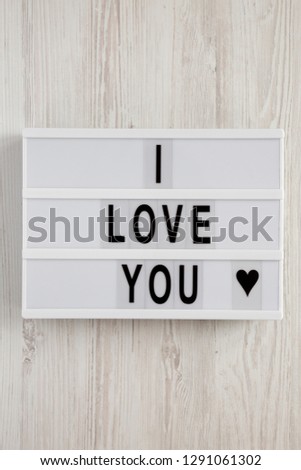 Modern board with text 'I Love You' on a white wooden background, top view. Flat lay, overhead. Valentine's Day 14 February.