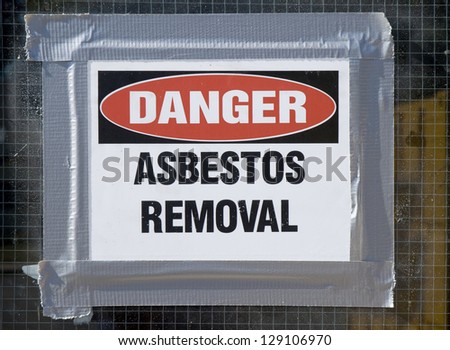 Danger Asbestos Removal Sign posted on school window.