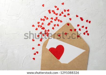 Valentines mother womens day minimal concept, hanmade gift - craft envelope, paper note, red paper hearts on gray background