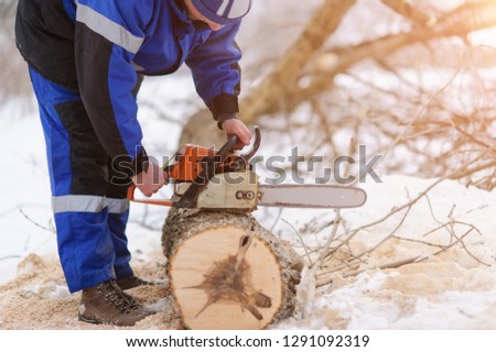 man repairing chainsaw on a winter background. Outdoor picture