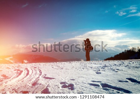 Photographer in winter mountain landscape