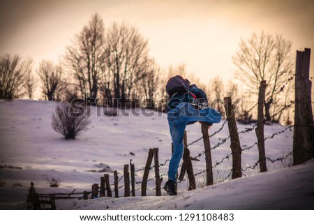 Man jumping barbed wire fence