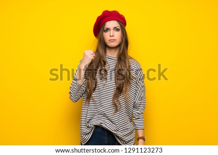Girl with french style over yellow wall with angry gesture