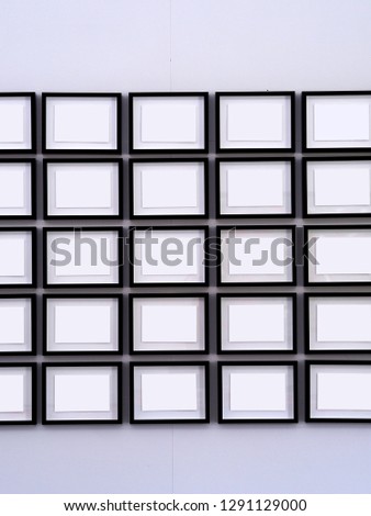Rows of black picture frames on white walls
