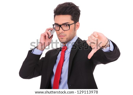 picture of a young business man calling someone and showing thumb down gesture, while looking at the camera on a white background