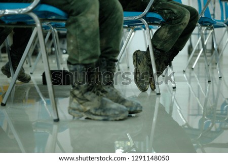 Soldiers' black shoes stained mud and marble floors.Focus on the rear shoes.