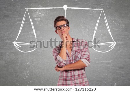confused young man pondering all the choices before making a decision Royalty-Free Stock Photo #129115220