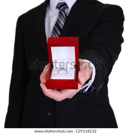 proposing man and holding up an engagement ring with box isolated on white background