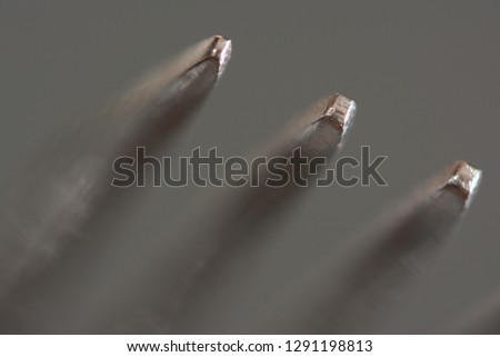 a macro look focused on the tine points of a fork with a gray background
