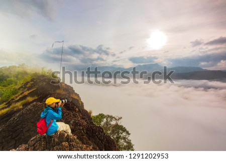Young girl are taking photos  the sea of mist on high mountain in Nakornchoom, Phitsanulok province, Thailand.