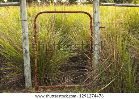 Land expropriation or private property concept image consisting of a rusty gate which serves as an entrance to a farm. 