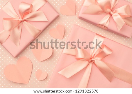 Valentines or Mothers day present box with bow ribbon decorated coral small hearts top view on  living coral color background. Concept decor gift box for love day or birthday. Flat lay.