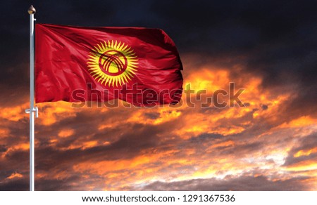 flag of Kyrgyzstan on flagpole fluttering in the wind against a colorful sunset sky