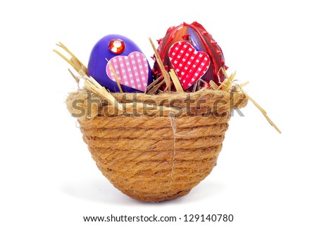 some easter eggs painted in different colors and with different ornaments on a nest