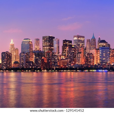 New York City Manhattan downtown skyline at dusk with skyscrapers illuminated over Hudson River panorama