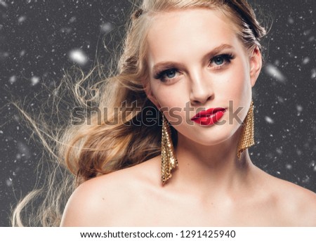 Beautiful woman blonde hair red lips winter background snow