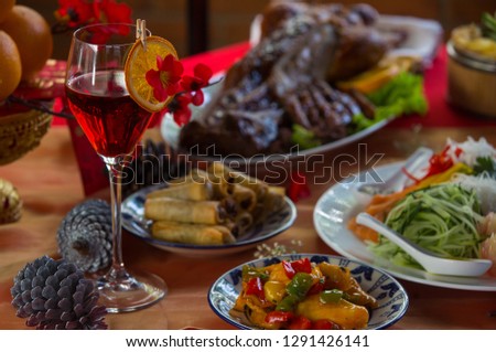 Chinese New Year party table in red and gold theme with food, drinks and traditional decorations.