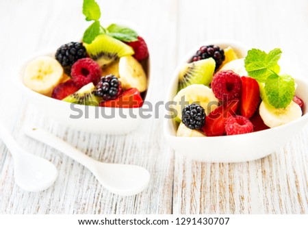 Bowls with fruit salad on a old wooden table