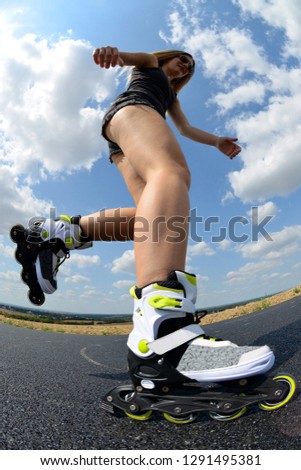 Teenage girl on roller skates. Inline skating on the road.