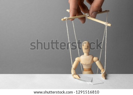 Puppeteer manipulates the doll. The conference is unfair. Fake person at conference or meeting. Fake news Royalty-Free Stock Photo #1291516810