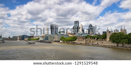 Cityscape panorama of the financial and banking district known as the City Of London, with the Tower of London alongside and the River Thames in the foreground. 