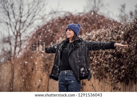 Beautiful woman on first snow this year. Gorgeous female enjoying snow outdoors. Winter photo snowing outside