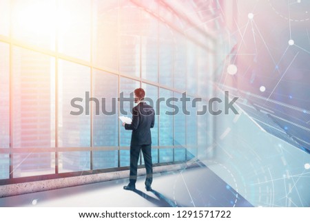 Rear view of businessman with documents standing in panoramic office looking at city with double exposure of blue red immersive interface. Concept of hi tech. Toned image