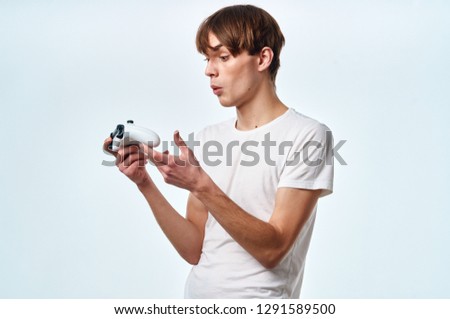 Surprised guy gamer holds controller hands on gaming console