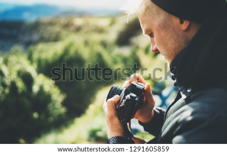 hipster tourist hold in hands taking photography click on retro vintage photo camera in auto, photographer looking on camera technology, sun flare mountain, panoramic landscape vacation hobby concept