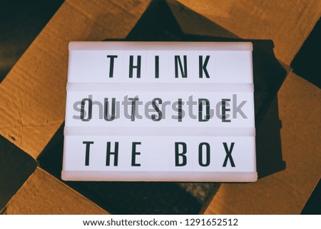 Think outside the box message on lightbox on top of open parcel, concept of being unique for success