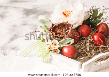 Easter background with a basket and red eggs with flowers, the bright interior, the concept of the Easter holidays
