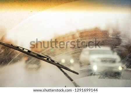 dirty car windshield with the included glass cleaner, in the big city front and back of the background is blurred Royalty-Free Stock Photo #1291699144