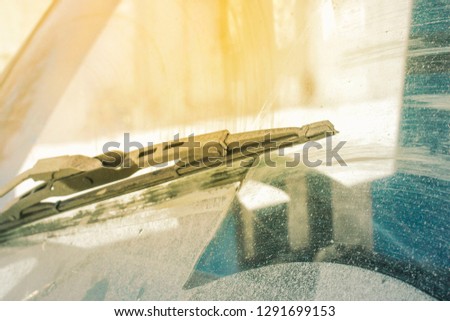 dirty car windshield with the included glass cleaner, in the big city front and back of the background is blurred Royalty-Free Stock Photo #1291699153