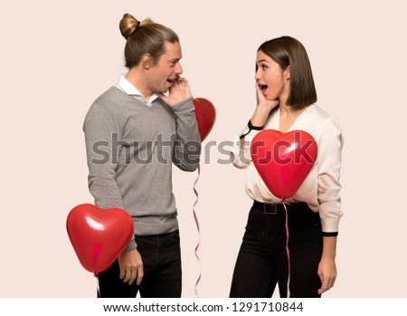 Couple in valentine day surprised and shocked while looking right over isolated background
