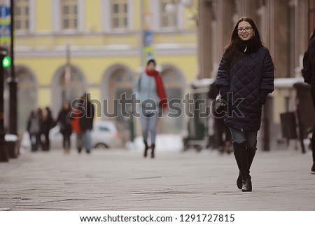 adult model girl in a coat on a winter walk in the city / Christmas vacation city tour