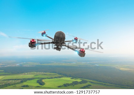 Drone quad copter with high resolution digital camera on the sky, flies over the terrain