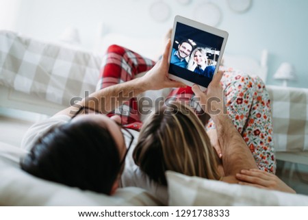 Young happy couple using tablet in bedroom