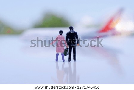 Travel concept.Traveler miniature people figure with bag walking on airport with airplane model.