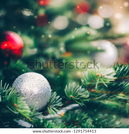 Fluffy fir decorated with silver glitter bauble close up. Christmas and new year background
